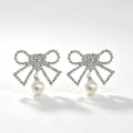 Crystal rhinestone bow earrings with pearl drop pendant in silver tone