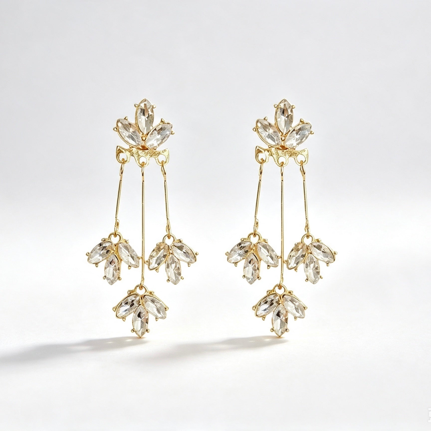Gold tone crystal marquise tassel drop earrings with triple strand and cluster drops