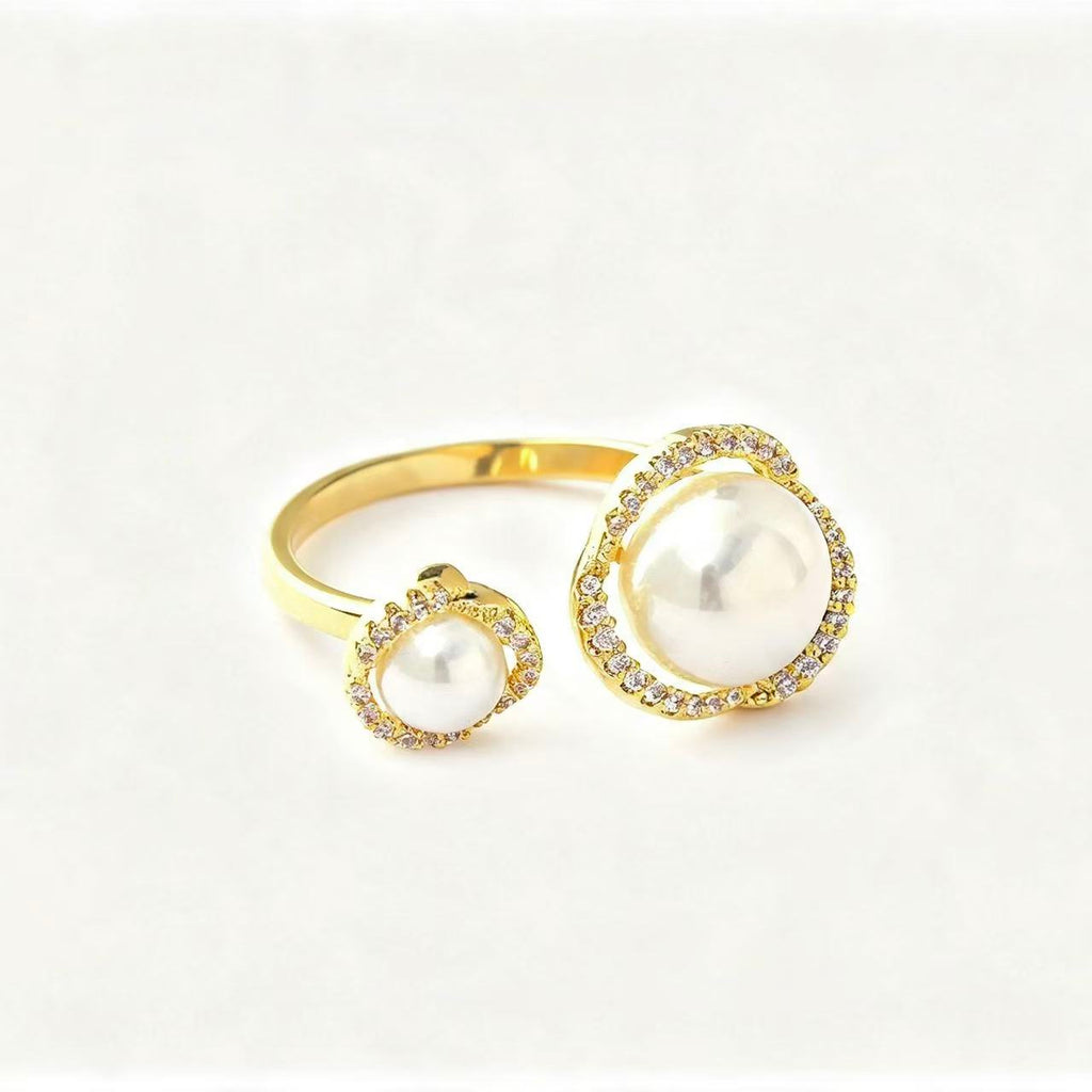 Gold open-band ring with two graduating faux pearls each set in a pavé crystal halo