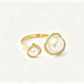 Gold open-band ring with two graduating faux pearls each set in a pavé crystal halo