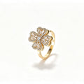 Gold spinning four-petal crystal flower ring with baguette and pavé CZ stones on a smooth gold band