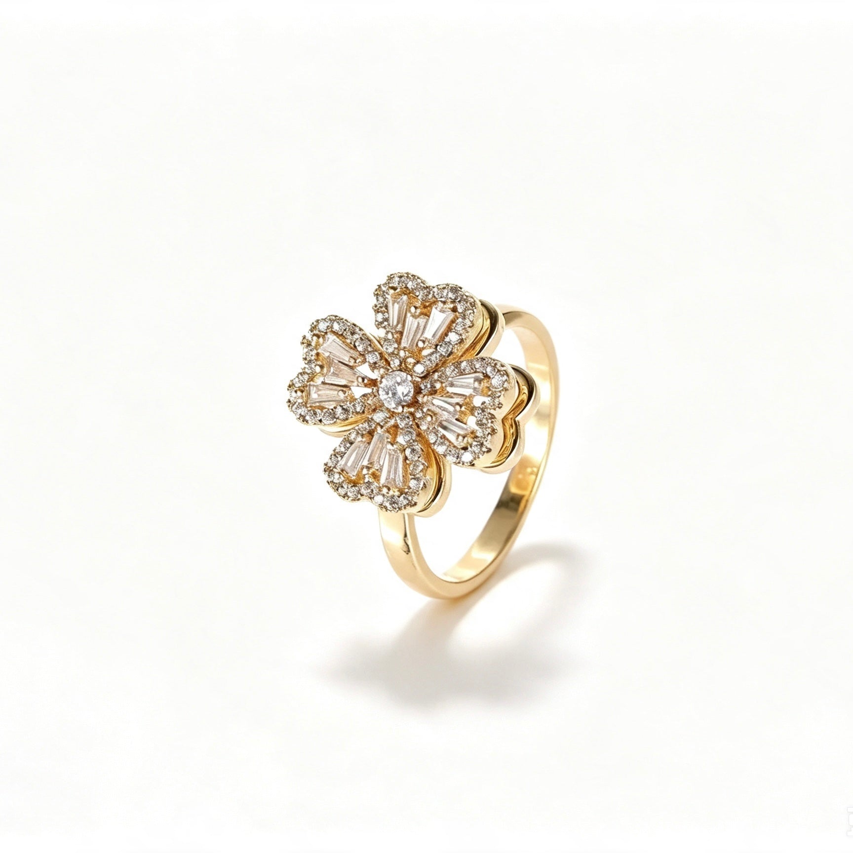 Gold spinning four-petal crystal flower ring with baguette and pavé CZ stones on a smooth gold band