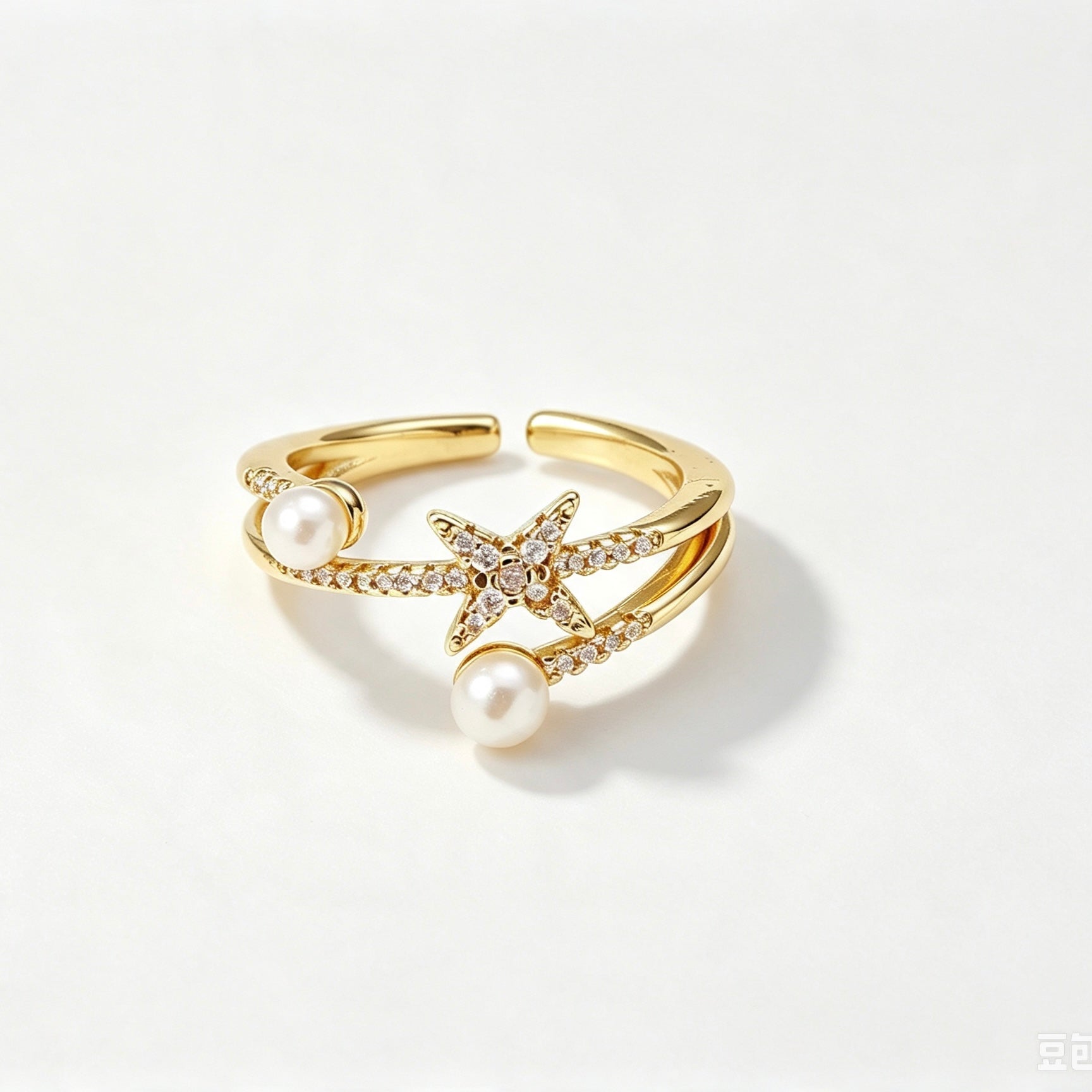 Gold double-band ring with pearl accents and crystal star centerpiece